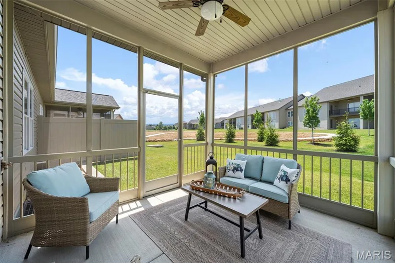 Screened-in porch featuring a ceiling fan, concrete flooring, and direct access to an expansive green space — 193 Santa Elena Drive, Wentzville, MO 63385