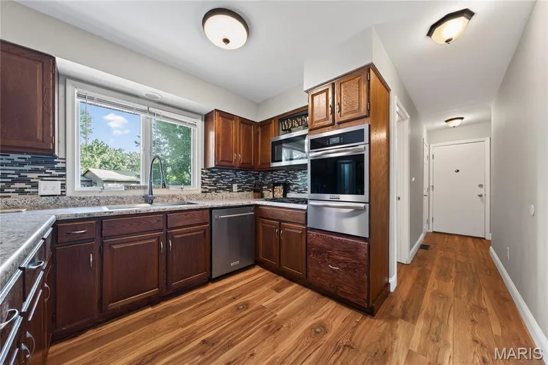 Kitchen has stainless appliances, built in oven (new in 8/26), gas range and custom tile backsplash — 72 Champagne Drive, Lake St. Louis, MO 63367