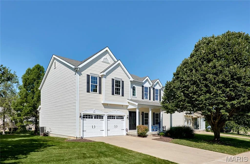 Classic two-story Colonial featuring white vinyl siding, dual gabled roofline, and symmetrical front elevation — 264 Greenshire Lane, Dardenne Prairie, MO 63368