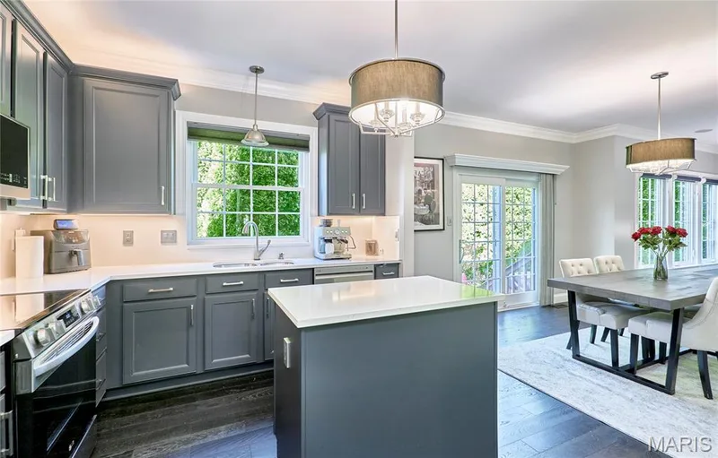 Kitchen featuring gray shaker-style cabinetry, white countertops, built-in stainless steel appliances, and a central island — 264 Greenshire Lane, Dardenne Prairie, MO 63368