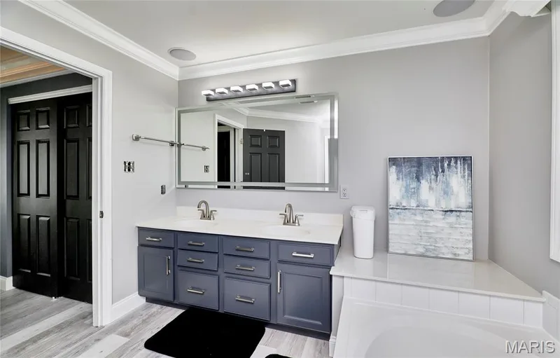 Spa-inspired primary bathroom featuring a dual-sink vanity with charcoal cabinetry, chrome hardware, and ample storage — 264 Greenshire Lane, Dardenne Prairie, MO 63368