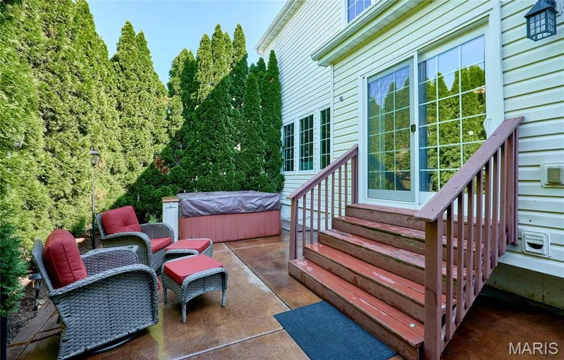 Expansive composite deck featuring rich wood-finish decking and matching railings, anchored by a covered hot tub with integrated seating — 264 Greenshire Lane, Dardenne Prairie, MO 63368