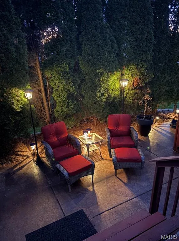 Concrete patio with ambient lighting and dense mature foliage — 264 Greenshire Lane, Dardenne Prairie, MO 63368