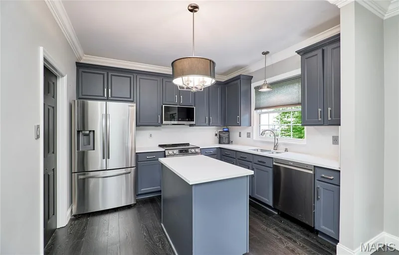 Kitchen featuring dark wood-finish flooring, a central island with a solid surface countertop, gray cabinetry, and stainless steel appliances — 264 Greenshire Lane, Dardenne Prairie, MO 63368
