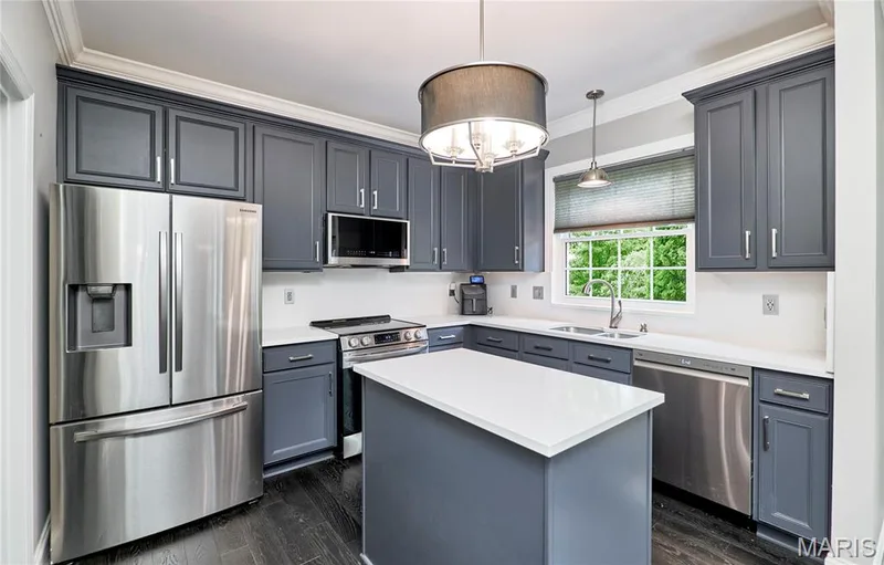 Kitchen featuring a central island, dark wood-finish flooring, white countertops, stainless steel appliances, and gray cabinetry with crown molding — 264 Greenshire Lane, Dardenne Prairie, MO 63368