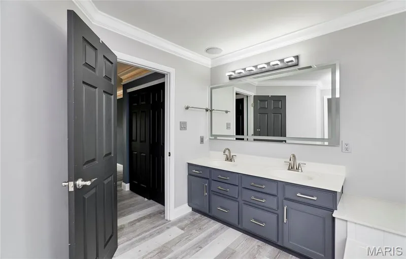 Double vanity with white countertop, chrome hardware, recessed lighting, and wood-finish flooring — 264 Greenshire Lane, Dardenne Prairie, MO 63368
