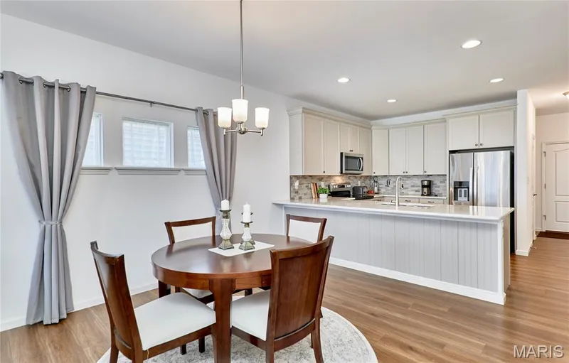 Kitchen with light cabinetry, stainless steel appliances, and a central island with a white countertop — 305 Copperfield Court, St Charles, MO 63301