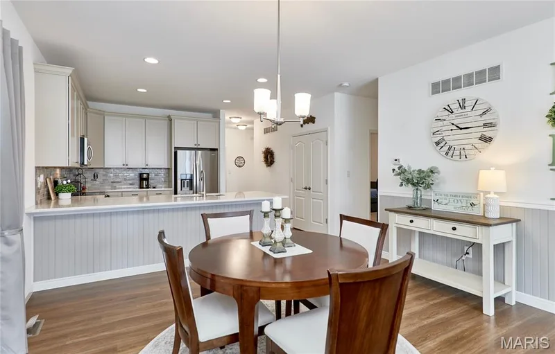 Kitchen featuring light-toned cabinetry, stainless steel appliances, and a tiled backsplash — 305 Copperfield Court, St Charles, MO 63301