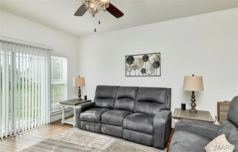 Wood-finish flooring with a neutral wall color, and a ceiling fan with integrated lighting — 305 Copperfield Court, St Charles, MO 63301