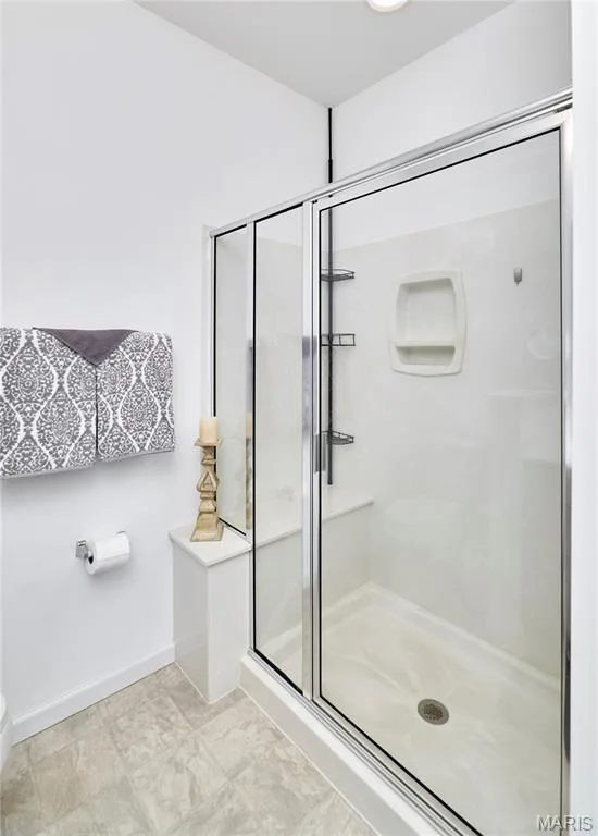 Shower enclosure with sliding glass doors, integrated shelving, and a built-in bench — 305 Copperfield Court, St Charles, MO 63301