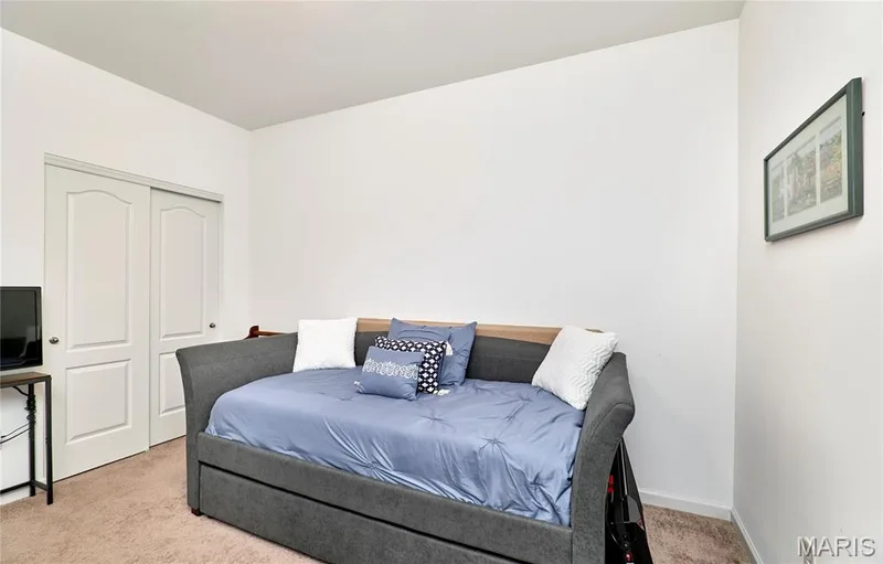 Carpeted room with white walls and a double-panel sliding closet door — 305 Copperfield Court, St Charles, MO 63301