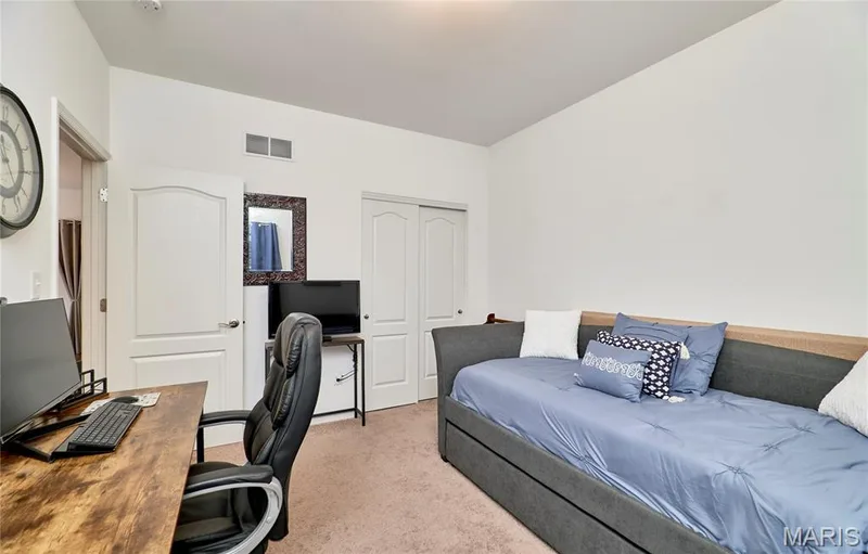 Carpeted room with a vaulted ceiling, arched interior doorways, and a sliding closet door — 305 Copperfield Court, St Charles, MO 63301