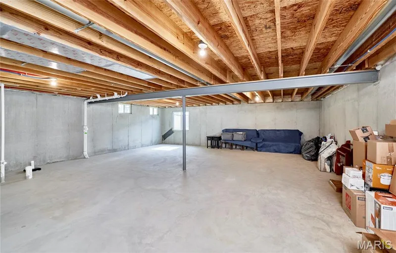 Unfinished basement with concrete flooring, exposed wood ceiling joists, and concrete foundation walls — 305 Copperfield Court, St Charles, MO 63301