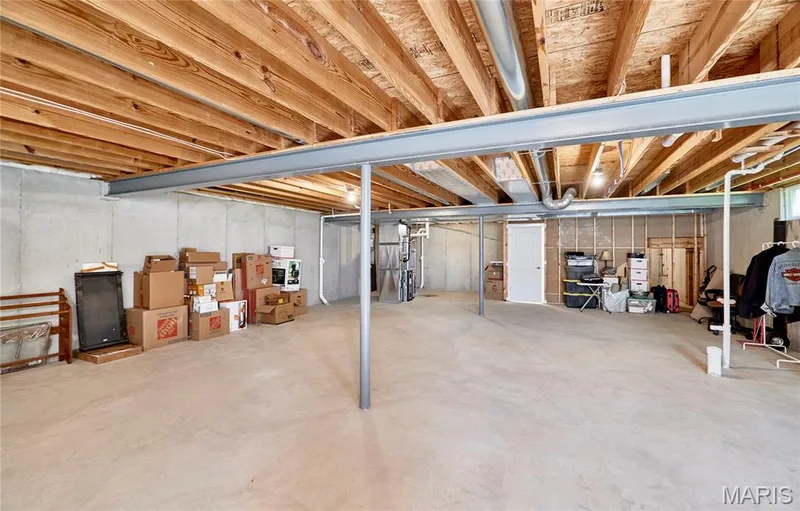Unfinished basement with exposed ceiling joists, concrete floor, and concrete foundation walls — 305 Copperfield Court, St Charles, MO 63301