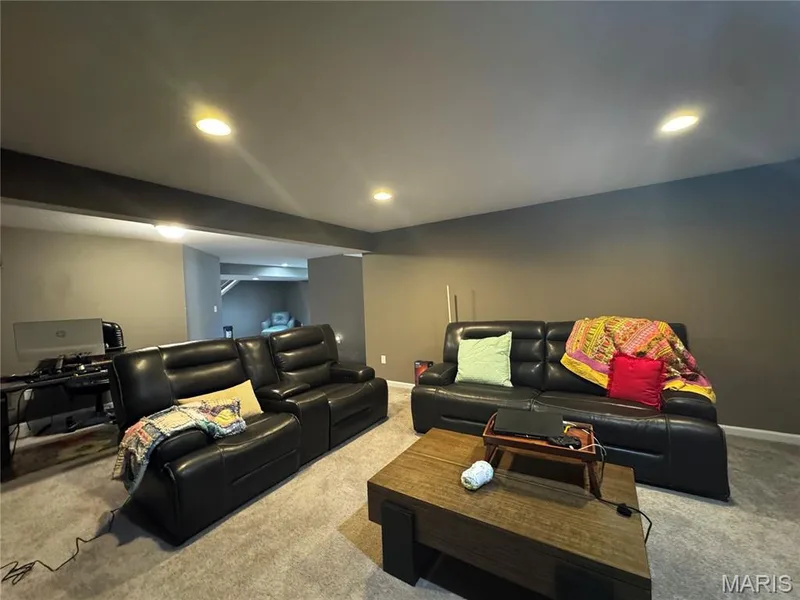 Recessed ceiling lighting, wall-to-wall carpeting, and a wood-finish coffee table — 401 Copperfield Court, St Charles, MO 63301