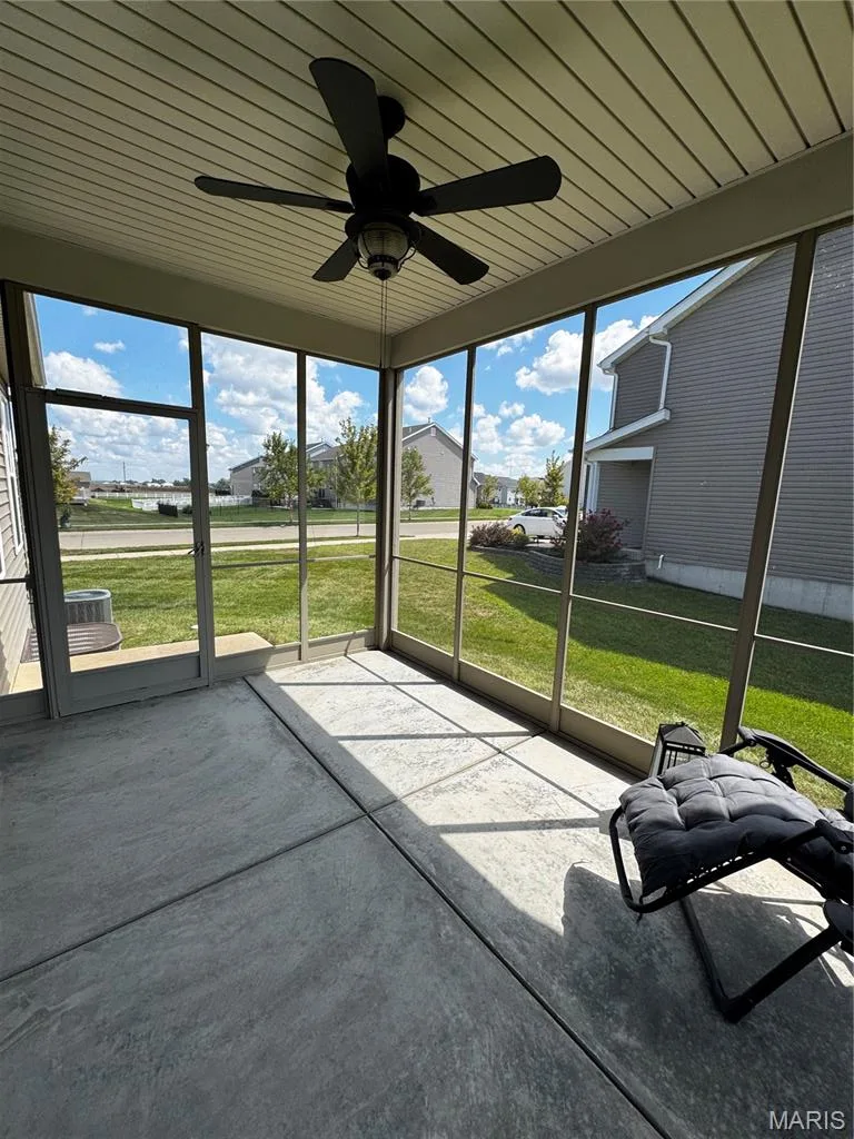 Screened-in porch featuring a concrete floor, ceiling fan, and access to the exterior — 401 Copperfield Court, St Charles, MO 63301