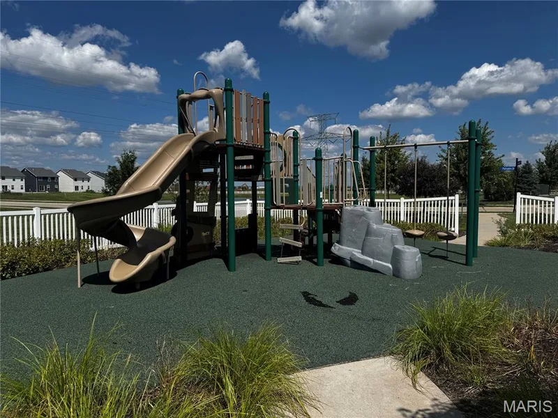 Playground structure featuring multiple slides, climbing elements, swings, and a resilient rubberized surface — 401 Copperfield Court, St Charles, MO 63301