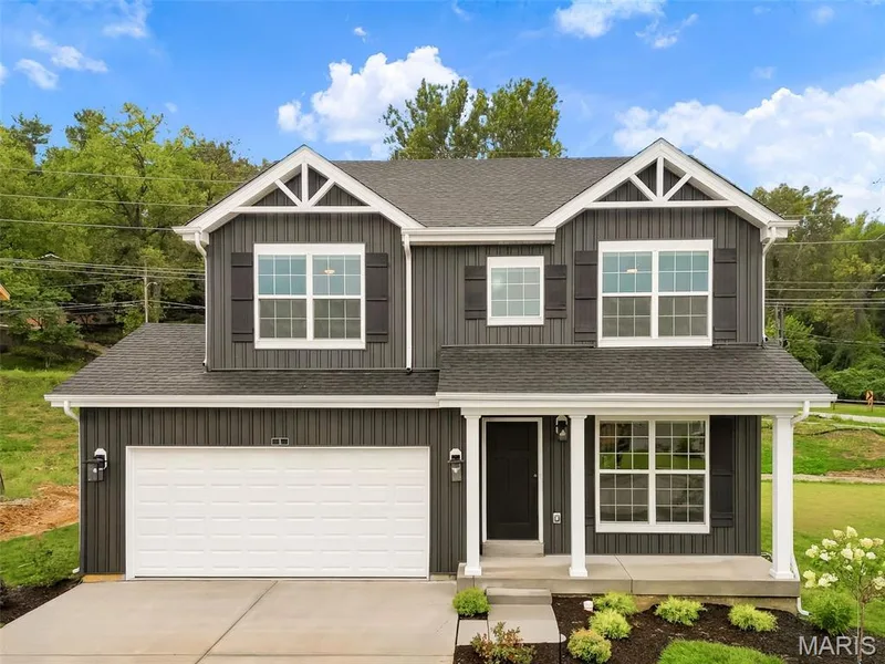 Two-story residence featuring dark vertical siding, white trim, a covered front porch, and an attached two-car garage — 8 Shady Elm Court, St Charles, MO 63301