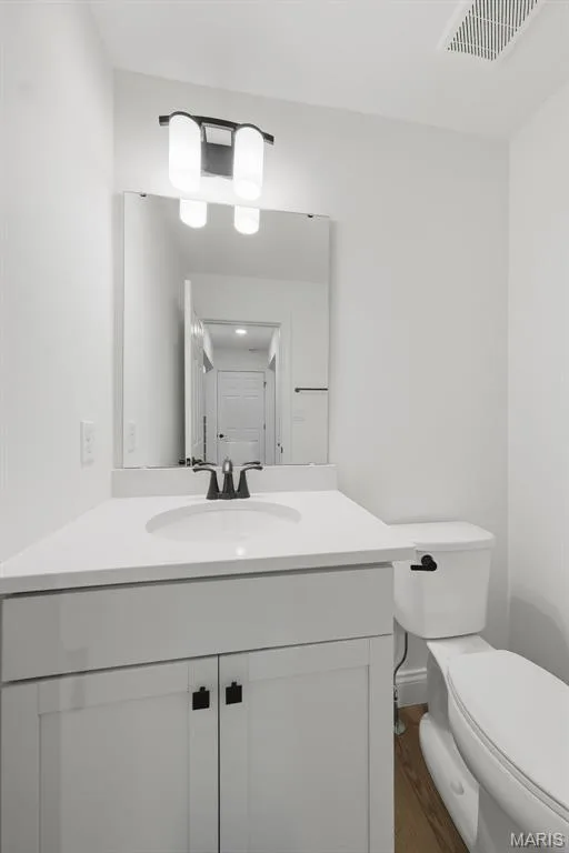 White vanity with recessed panel cabinet doors and dark hardware, integrated sink, and dark faucet — 8 Shady Elm Court, St Charles, MO 63301