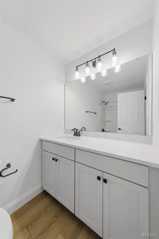 White vanity with matte black hardware, integrated sink, and white countertop — 8 Shady Elm Court, St Charles, MO 63301
