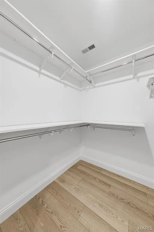 Wood-finish flooring with white baseboards, white walls, and built-in closet shelving — 8 Shady Elm Court, St Charles, MO 63301