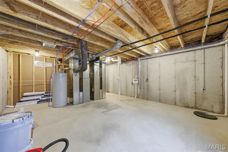 Unfinished basement with concrete flooring and exposed ceiling joists — 8 Shady Elm Court, St Charles, MO 63301