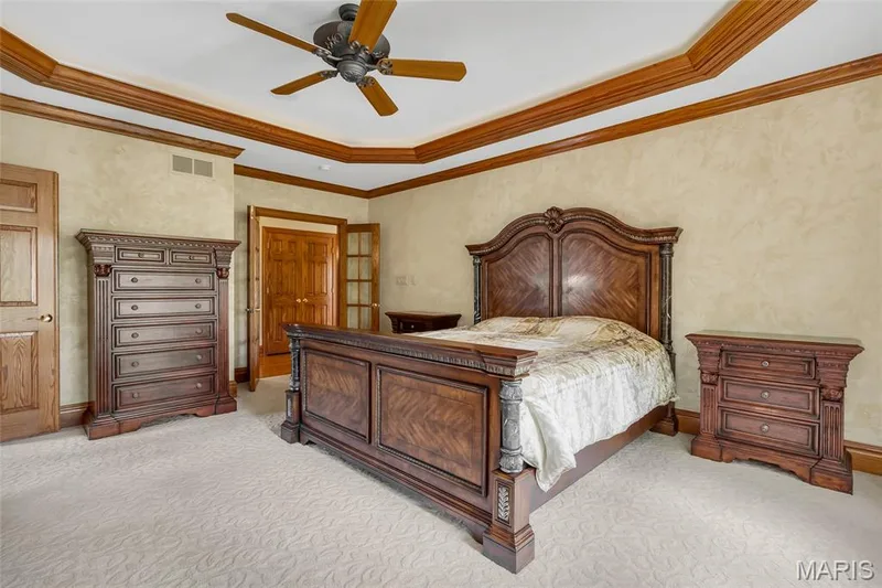The spacious primary suite features a beautiful tray ceiling, extensive crown molding, and a peaceful atmosphere designed for relaxation. — 4030 Austin Drive, St Charles, MO 63304