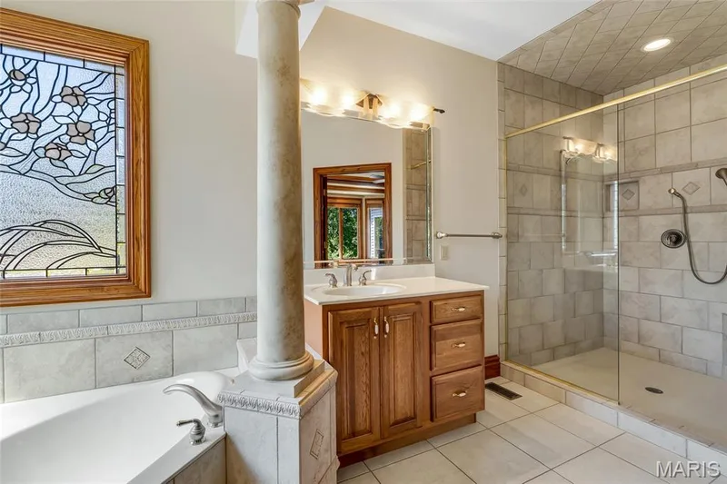 Unwind in the luxurious primary bath, complete with a large walk-in shower designed for a relaxing, spa-inspired experience. — 4030 Austin Drive, St Charles, MO 63304