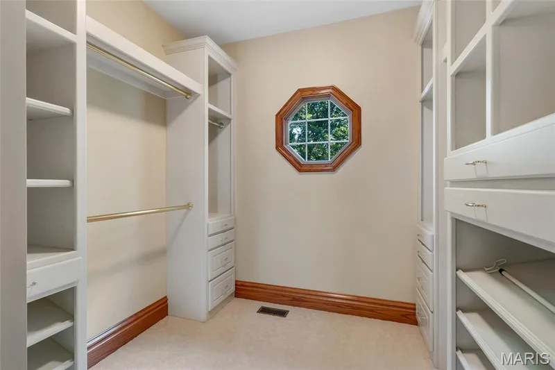 The spacious primary walk-in closet is thoughtfully designed with custom organization, providing ample space for clothing, shoes, and accessories. — 4030 Austin Drive, St Charles, MO 63304