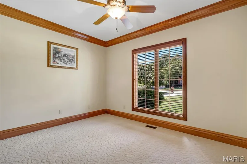Second main-floor bedroom featuring crown molding and abundant natural light. — 4030 Austin Drive, St Charles, MO 63304