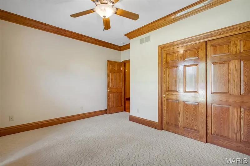 Second main-floor bedroom featuring crown molding and abundant natural light. — 4030 Austin Drive, St Charles, MO 63304