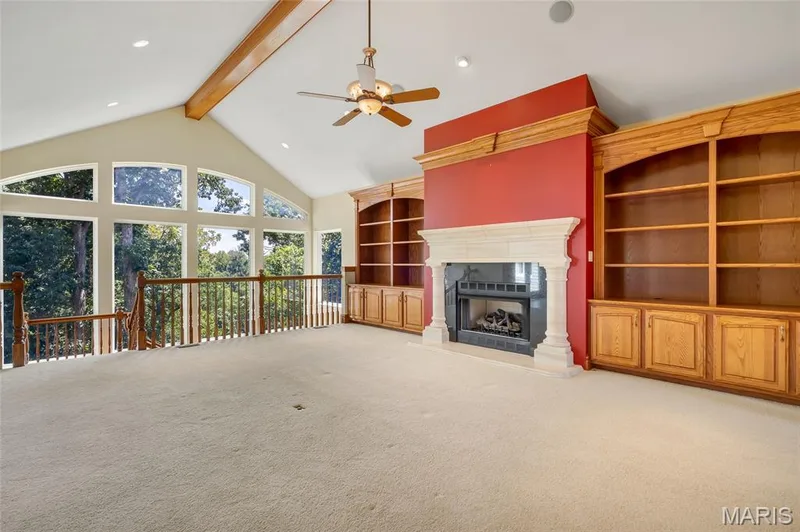 Designed for both comfort and entertaining, the living room showcases a beautiful gas fireplace surrounded by custom built-in shelving, creating an inviting space to gather and relax. — 4030 Austin Drive, St Charles, MO 63304
