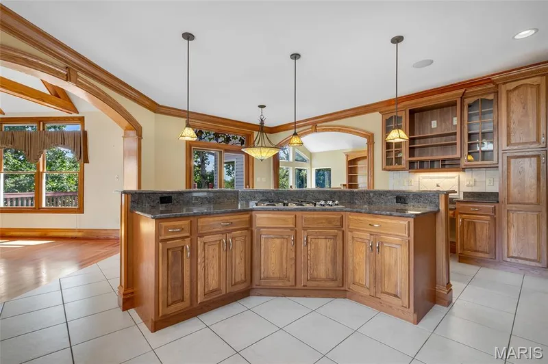 Designed with the home chef in mind, the oversized kitchen island boasts a gas cooktop and built-in spice cabinet, keeping essentials within easy reach while maximizing workspace. — 4030 Austin Drive, St Charles, MO 63304