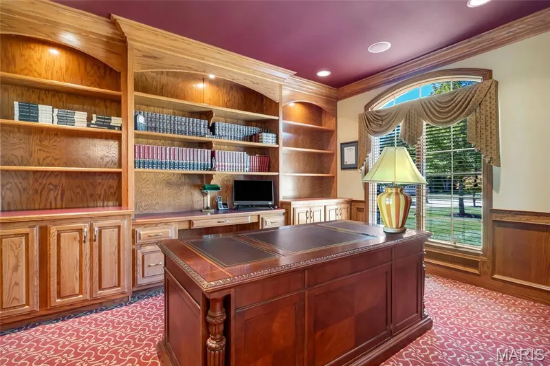 Dedicated office space with a beautifully illuminated wall of built-in shelving, perfect for displaying books, décor, and cherished keepsakes. — 4030 Austin Drive, St Charles, MO 63304