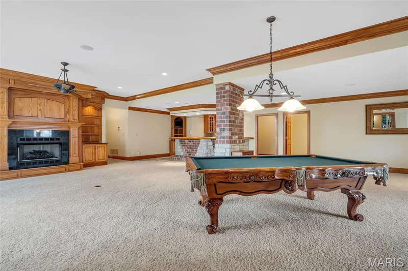 Another gas fireplace surrounded by custom built-ins with accent lighting, creating a warm and inviting gathering space. — 4030 Austin Drive, St Charles, MO 63304