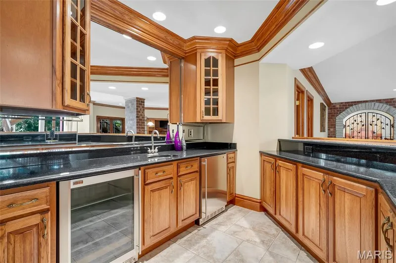 Perfect for hosting guests, the expansive wet bar features a sink, two beverage refrigerators, and exceptional storage, making it as functional as it is stylish. — 4030 Austin Drive, St Charles, MO 63304