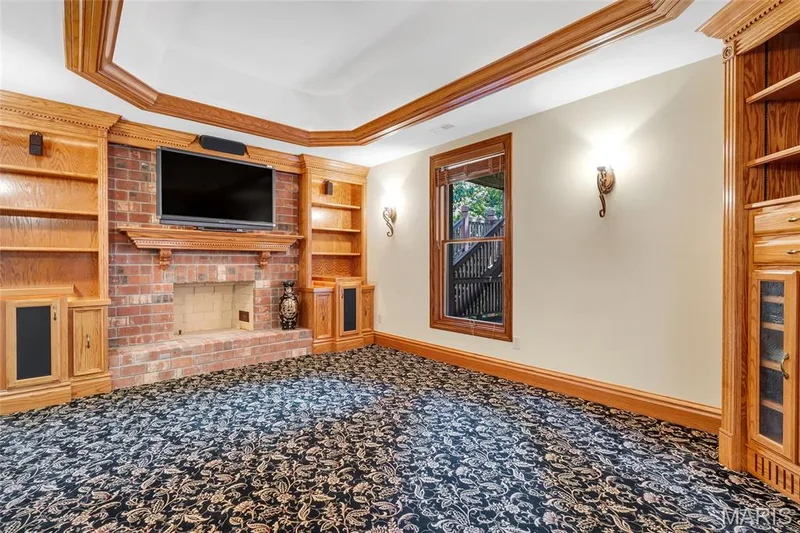 The dedicated media room features all the hardwiring needed for a premium entertainment setup, centered around a cozy fireplace, making it the perfect place to enjoy movies, sports, gaming, or your favorite shows. — 4030 Austin Drive, St Charles, MO 63304