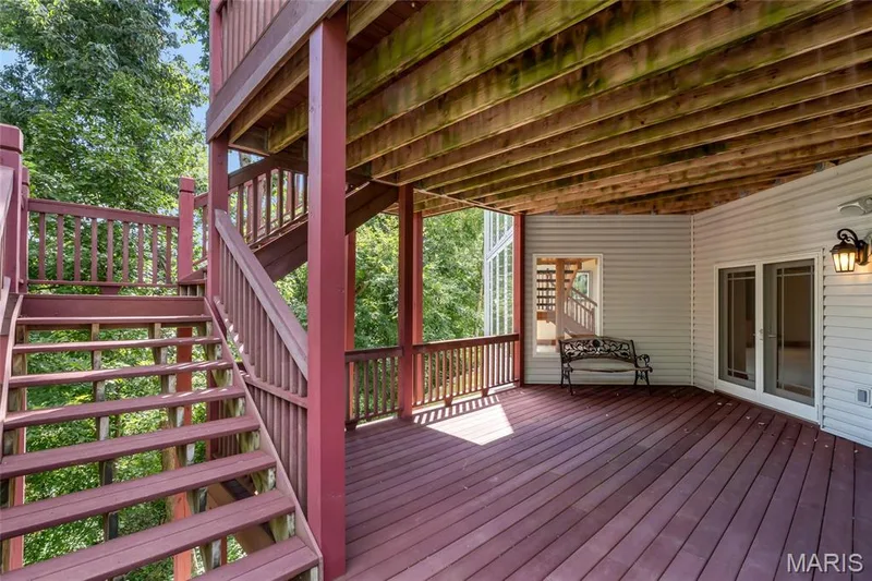 Step outside from the recreation room to the covered lower-level composite deck, offering a comfortable outdoor living space sheltered from the elements. — 4030 Austin Drive, St Charles, MO 63304