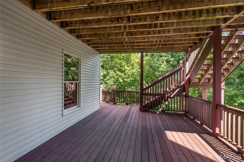 Step outside from the recreation room to the covered lower-level composite deck, offering a comfortable outdoor living space sheltered from the elements. — 4030 Austin Drive, St Charles, MO 63304