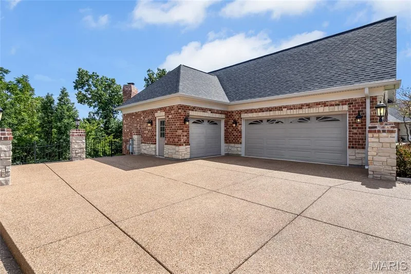 The oversized 3-car garage and aggregate driveway provide ample parking. — 4030 Austin Drive, St Charles, MO 63304