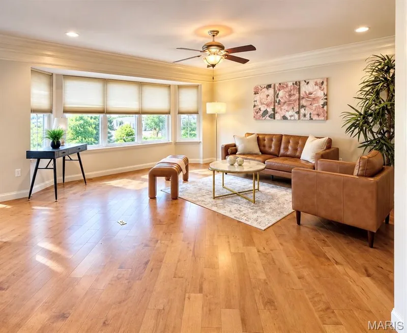 Expansive room featuring wood-finish flooring, a bay window with multiple panes, ceiling fan, recessed lighting, and crown molding — 3105 Wheeling Drive, St Charles, MO 63301