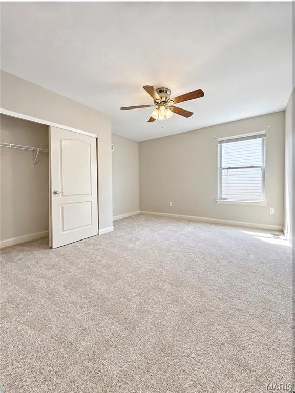 Neutral-toned carpeting, ceiling fan with integrated lighting, and a window with blinds — 3105 Wheeling Drive, St Charles, MO 63301
