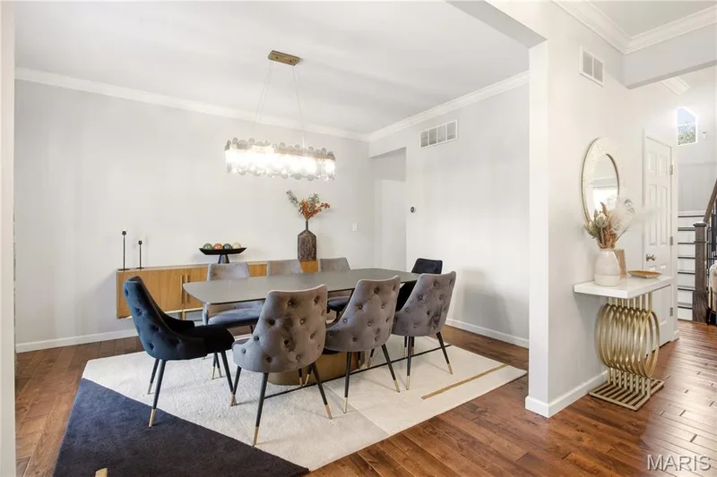 Wood-finish flooring, crown molding, and a statement linear chandelier — 308 Graywynd Court, Lake St. Louis, MO 63367