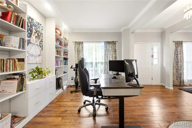 Wood-finish flooring throughout, complemented by built-in shelving and cabinetry, and crown molding — 308 Graywynd Court, Lake St. Louis, MO 63367