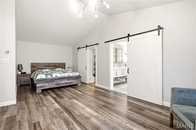 Master Bedroom. Vaulted ceilings, wood-finish flooring, and white barn doors — 308 Graywynd Court, Lake St. Louis, MO 63367