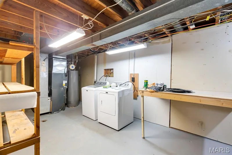 Utility Room/Laundry Room.  Our Photographer thought this room was so clean, he wanted to take a photo.  Has workbench for hobbies/crafts and lots of storage shelving for those holiday decorations. — 3424 La Salle Drive, St Charles, MO 63301