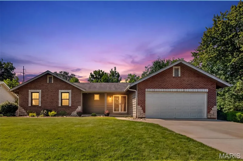Brick and siding exterior with stone accents, attached garage, concrete driveway, and a front lawn — 19 Novella Drive, St Peters, MO 63376