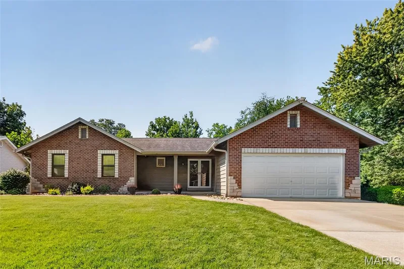 Brick and siding exterior with stone accents, attached two-car garage, concrete driveway, and manicured front lawn — 19 Novella Drive, St Peters, MO 63376