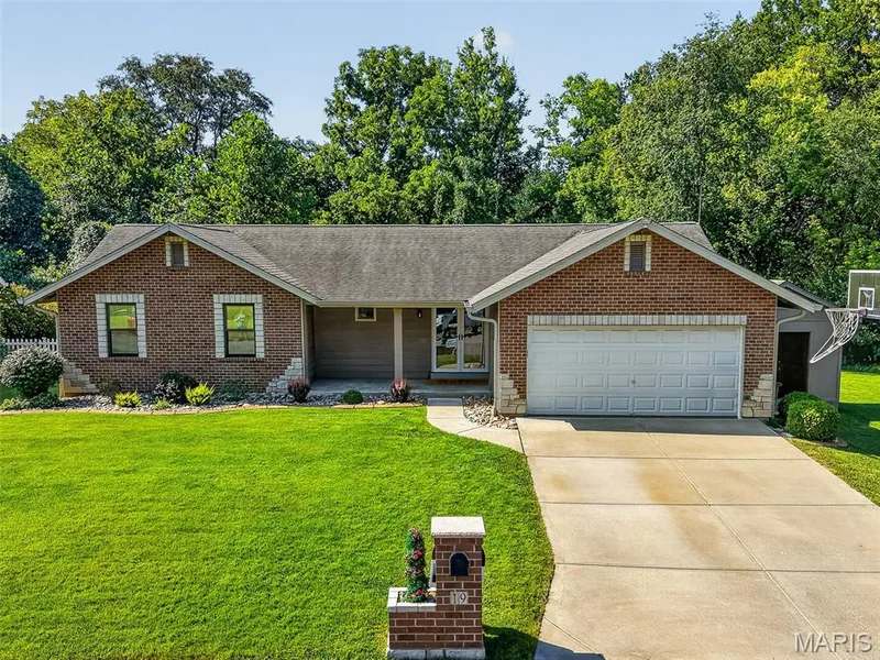 Brick exterior with stone accents, attached garage, concrete driveway, and front lawn — 19 Novella Drive, St Peters, MO 63376