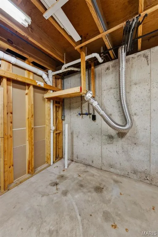 Unfinished basement space featuring exposed concrete walls, concrete flooring, and exposed ceiling joists with visible utilities — 19 Novella Drive, St Peters, MO 63376